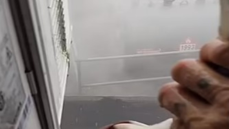 Η στιγμή που ένας άντρας ανοίγει το παράθυρο του σπιτιού κατά την διάρκεια του τυφώνα Άιντα (vid)