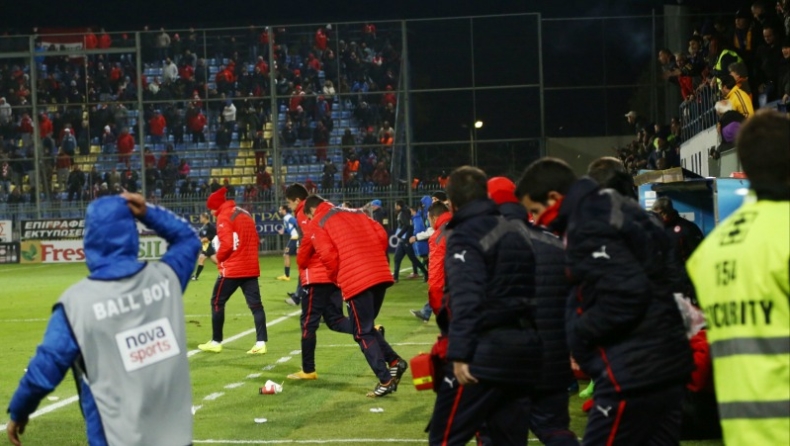Αντικείμενα σε αγωνιστικό χώρο και ερυθρόλευκο πάγκο