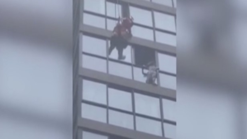 Η στιγμή που πυροσβέστης προσπαθεί να σώσει κορίτσι που κρέμεται έξω από παράθυρο του 13ου ορόφου (vid)